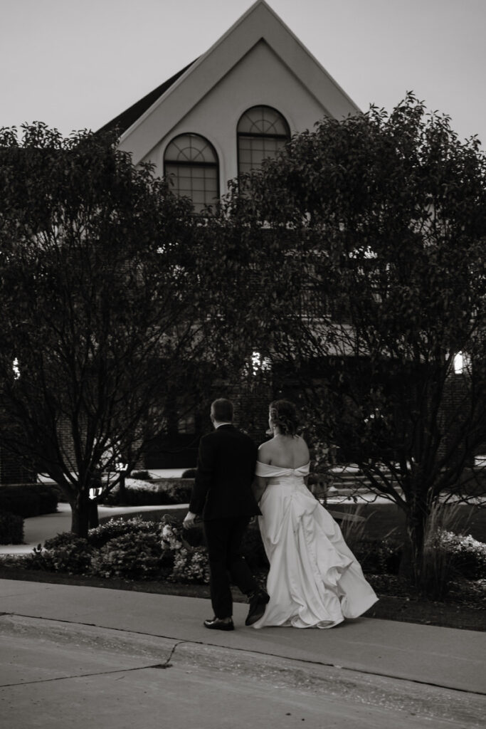 Newlyweds walking down a sidewalk together 