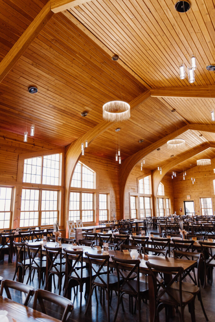 A wedding reception set up with rectangular, simply decorated tables 