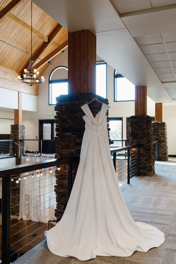 A wedding dress hanging from a stone pillar 