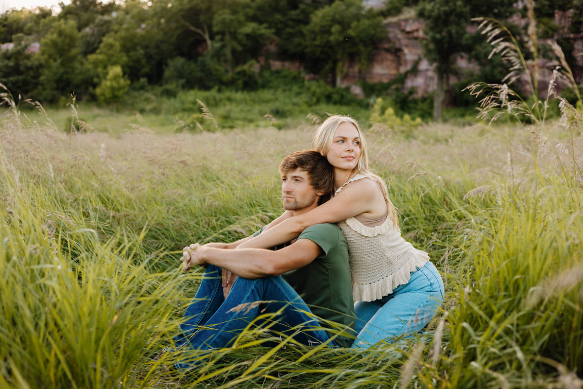 Photoshoot outfit ideas showing two people sitting in a field together