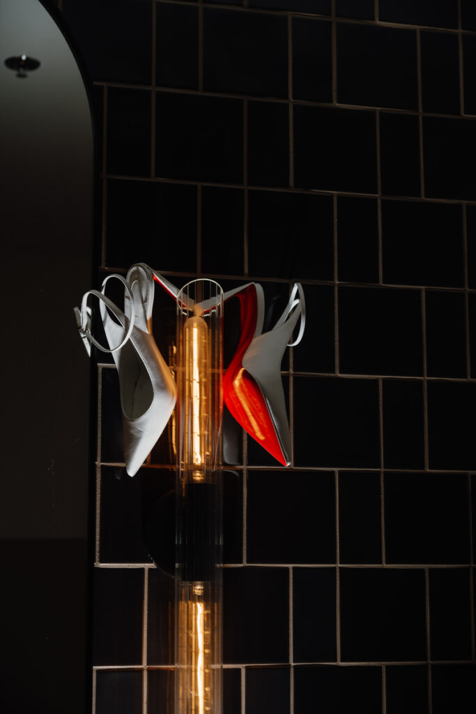 White heels hanging from a light fixture 