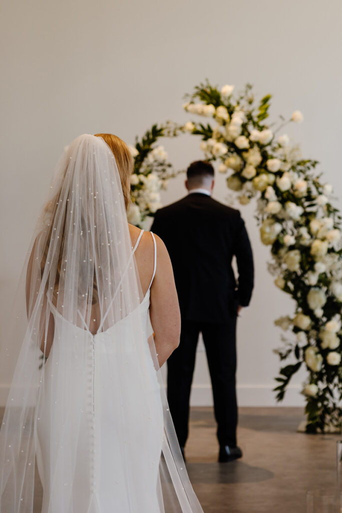 A person standing behind their partner before their first look 